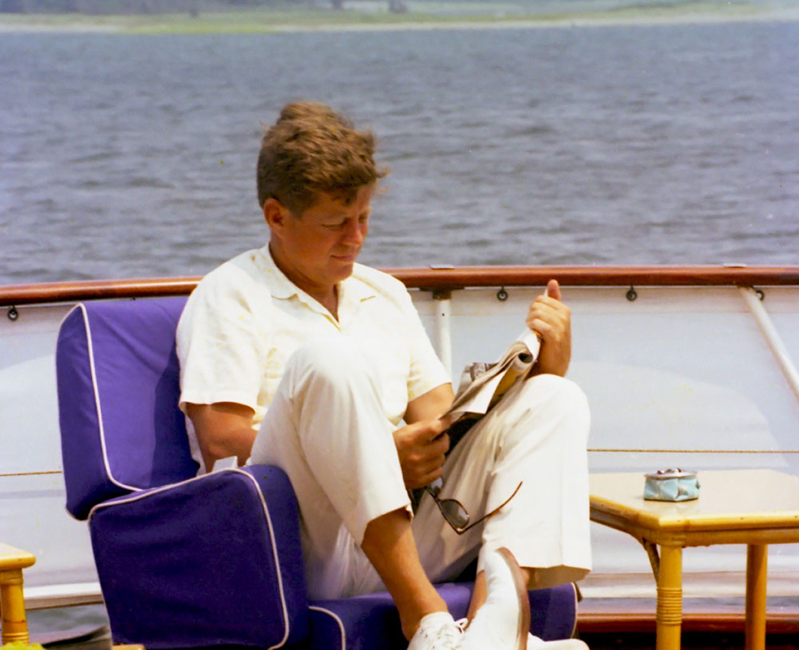 JFK reading on the bow of Honey Fitz