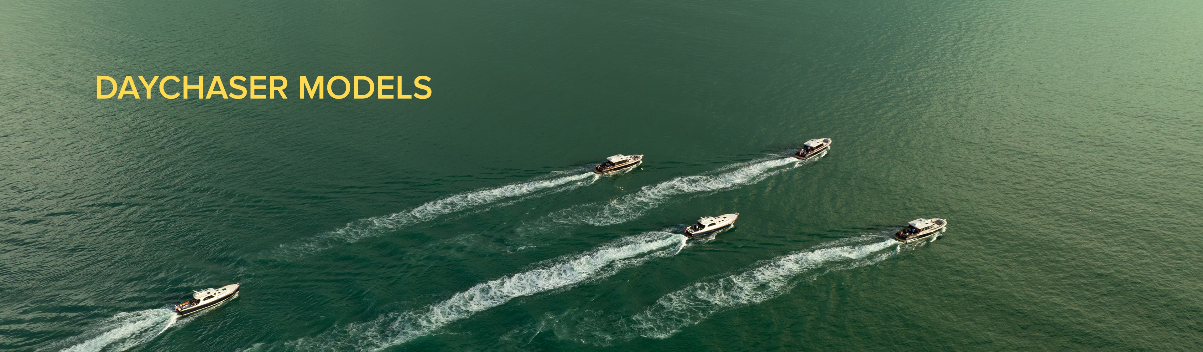 Aerial shot of a fleet of daychasers cruising through the aqua green water.